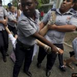 Cuban security personnel detain a member of the Ladies in White group after their weekly anti-government protest march, in Havana
