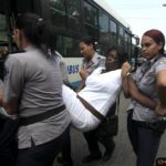 Cuban security personnel detain a member of the Ladies in White group after their weekly anti-government protest march, in Havana