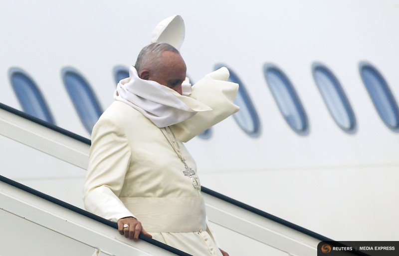 A gust of wind blows off Pope Francis’ cap during his arrival at the airport in Havana