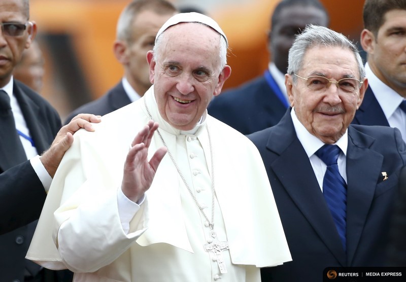 Pope Francis waves as he arrives, accompanied by Cuba’s President Raul Castro, at the Havana airport