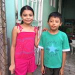 Two children in front of their home in Pavas, Costa Rica.