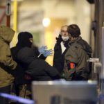 Masked Belgian police secure the entrance to a building in Schaerbeek