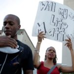 Alex Brown carries his two-month-old son Noah as his wife Lakeisha carries a sign during a Black Lives Matter protest in Washington