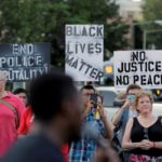 Demonstrators with Black Lives Matter hold up signs before a protest march in Washington