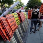 Demonstrators with Black Lives Matter gather signs before a protest march in Washington