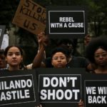 Protesters hold signs ahead of a march against police brutality in Manhattan, New York