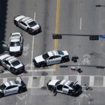 Police cars remain parked with the pavement marked by spray paint, in an aerial view of the crime scene of a shooting attack in downtown Dallas