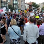 Pedestrians watch as demonstrators with Black Lives Matter march during a protest in Washington