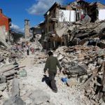 A man walks amidst rubble following an earthquake in Pescara del Tronto
