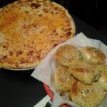 Cheese pizza and a basket of garlic rolls