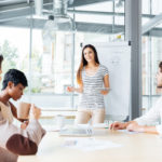 storyblocks/Smiling woman making presentation for business people in office