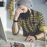 storyblock/Frustrated young man at computer desk