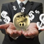 storyblock/Businessman shows a piggy bank