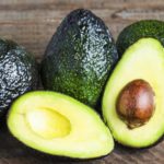 fresh-avocadoes-sliced-on-a-wood-cutting-board-16×9