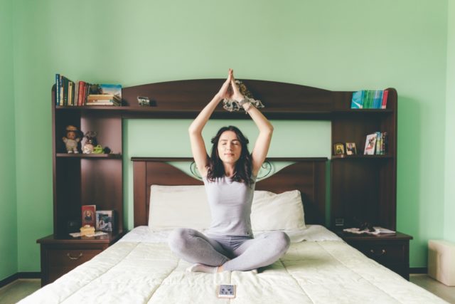 storyblocks/graphicstock-young-beautiful-eastern-woman-doing-yoga-on-bed-indoor-in-apartment-relaxing-meditation-quiet-concept_HpNlqNcJb body