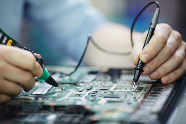 storyblocks-closeup-shot-of-male-hands-testing-electric-current-voltage-in-circuit-board-of-disassembled-laptop-using-multimeter-tool-on-table-in-maintenance-shop_Habw0QpmbM