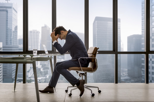 freepik/Stressed young businessman overworking