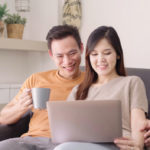 asian-couple-using-laptop-drinking-warm-cup-coffee-living-room-home-sweet-couple-enjoy_7861-1170
