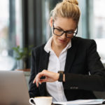 cheerful-business-woman-looking-watch_171337-2877