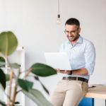 smiling-satisfied-man-30s-wearing-white-shirt-sitting-table-office-having-business-chat-silver-laptop_171337-39382
