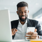 young-african-american-business-man-using-phone-making-winner-gesture-with-fist-office_231208-694