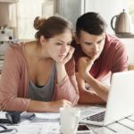 young-man-woman-working-together-laptop-paying-utility-bills-via-internet-using-online-mortgage-calculator-save-money-home-loan-looking-screen-with-serious-concentrated-expression_273609-1662
