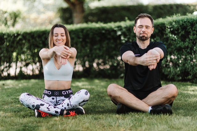 https://www.pexels.com/photo/couple-sitting-on-grass-warming-up-4378999/