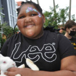 Isabelle, a client of the Lighthouse of Broward holds a bunny.