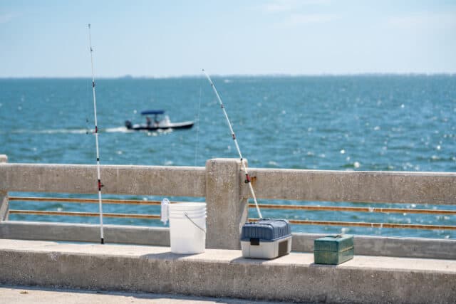 Photo of fishing poles and tackle boxes on a pier https://www.vecteezy.com/photo/1421494-fishing-poles-and-tackle-boxes-on-a-pier