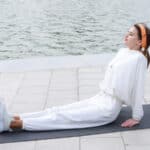 Young athlete sittin on yoga mat at the park. High quality photo