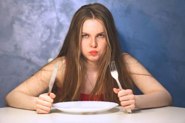 Hungry young woman waiting with an empty plate. https://www.freepik.com/premium-photo/hungry-young-woman-waiting-with-empty-plate_10294751.htm#query=hungry&from_query=hangry&position=28&from_view=search