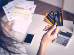 https://www.vecteezy.com/photo/2102186-close-up-woman-s-hand-holding-three-credit-cards-and-papers-at-a-desk-with-calculator-and-a-cell-phone