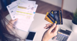 https://www.vecteezy.com/photo/2102186-close-up-woman-s-hand-holding-three-credit-cards-and-papers-at-a-desk-with-calculator-and-a-cell-phone