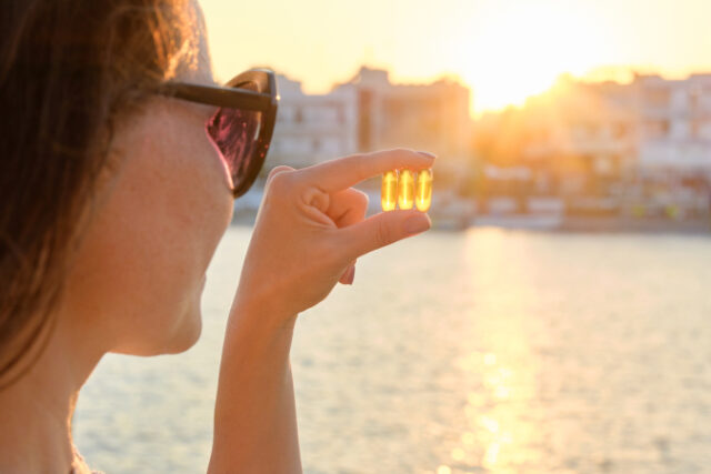 Yellow gel capsule vitamin d omega-3 in womans hand, sun sea background. https://www.freepik.com/premium-photo/yellow-gel-capsule-vitamin-d-omega3-womans-hand-sun-sea-background_24745440.htm#query=vitamin%20d&position=21&from_view=search