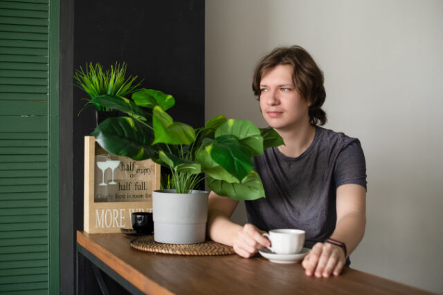 https://www.vecteezy.com/photo/10830138-a-positive-teenage-guy-sits-at-the-table-at-home-in-the-kitchen-with-a-cup-of-coffee-in-a-glass-relaxes-and-rests-in-the-morning