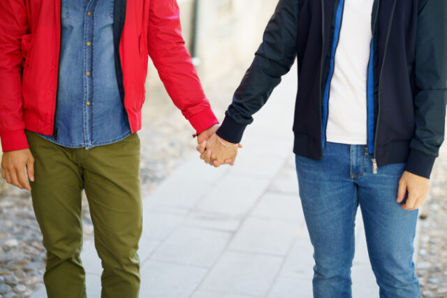 Gay couple holding hands in the street. Homosexual relationship concept. https://www.vecteezy.com/photo/4901666-gay-couple-holding-hands-in-the-street