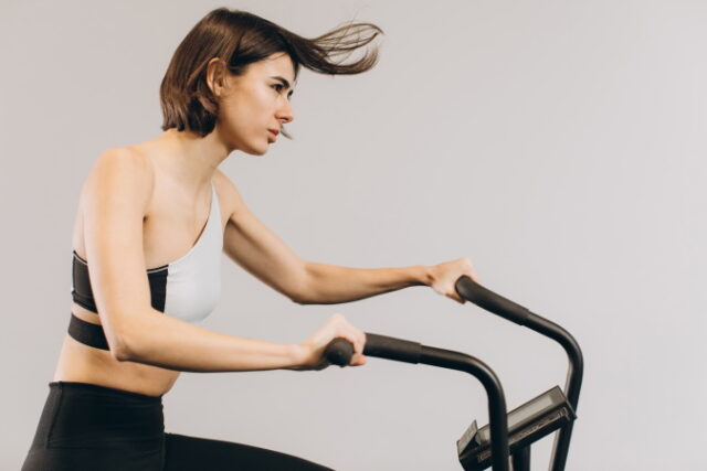 Crossfit woman doing intense cardio training on exercise air bike https://www.vecteezy.com/photo/8034901-crossfit-woman-doing-intense-cardio-training-on-exercise-air-bike