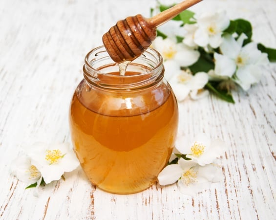 Honey with jasmine flowers on a wooden background https://www.vecteezy.com/photo/2510581-honey-with-jasmine-flowers-on-a-wooden-background