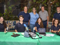 Lighthouse of Broward VP of Strategic Initiatives and Development Jose Lopez Masso, President and CEO Ellyn Drotzer and American Heritage School Director of the Pre-engineering Program William Moss (standing, back center) with American Heritage School student volunteers.