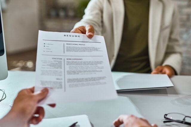 Close-up of candidate giving his CV on a job interview. https://www.freepik.com/free-photo/closeup-job-applicant-giving-his-resume-during-job-interview-office_26346646.htm#query=grad%20job%20interview&position=45&from_view=search&track=ais