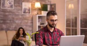 https://www.freepik.com/free-photo/bearded-freelancer-working-laptop-living-room-girlfriend-relaxing-sofa-background-using-her-phone-chips_21518690.htm#query=looking%20computer&position=10&from_view=search&track=ais