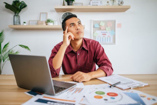A man works in an office with a laptop. https://www.freepik.com/free-photo/man-works-office-thinks-fixing-tasks_20615914.htm#query=thinking&position=14&from_view=search&track=sph
