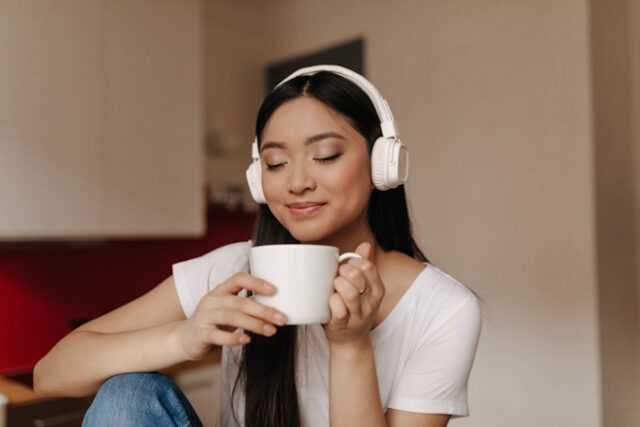 Attractive Asian woman in headphones inhale aroma of tea, holding cup and smiling. https://www.freepik.com/free-photo/attractive-asian-woman-headphones-inhale-aroma-tea-holding-cup-smiling_13400291.htm#query=coffee%20and%20music&position=30&from_view=search&track=country_rows_v1