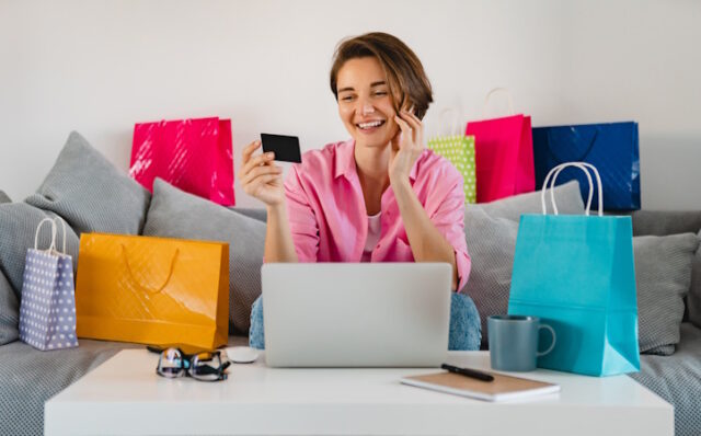 happy smiling woman in pink shirt on sofa at home shopping online https://www.freepik.com/free-photo/happy-smiling-woman-pink-shirt-sofa-home-among-colorful-shopping-bags-holding-credit-card-paying-online-laptop_14452610.htm#query=online%20shopping&position=22&from_view=search&track=ais