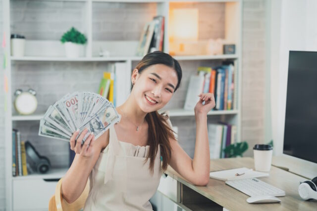 https://www.vecteezy.com/photo/24091300-asian-woman-girl-smiling-and-holding-dollar-bill-on-wood-table-desk-in-living-room-at-home-saving-investment-wealth-concept