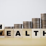 Hand flipping wording between wealth and health with coins stack