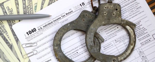 Police handcuffs lie on the tax form 1040. The concept of proble https://www.vecteezy.com/photo/13613333-police-handcuffs-lie-on-the-tax-form-1040-the-concept-of-problems-with-the-law-in-the-aftermath-of-non-payment-of-taxes