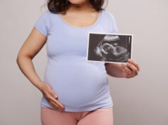 https://www.vecteezy.com/photo/23731196-cropped-view-pregnant-woman-caressing-her-belly-showing-at-camera-the-newborn-baby-ultrasound-scan-over-white-backdrop