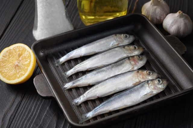 Fresh sardines on rustic wooden background. https://www.vecteezy.com/photo/8939390-fresh-sardines-on-rustic-wooden-background