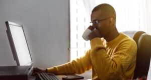 https://www.vecteezy.com/photo/42233027-latin-american-young-adult-man-have-a-cup-of-coffee-while-working-on-his-desktop-computer